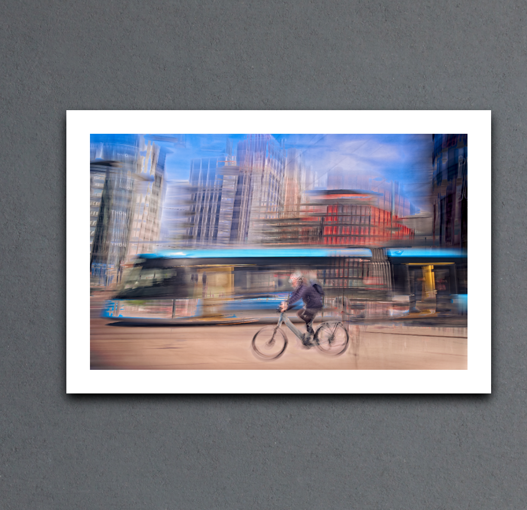 Downtown Deadline, a cyclist racing a tram through Oslo city streets — ICM photography cycling wall art print by Douglas Carr at Oslo Art Prints