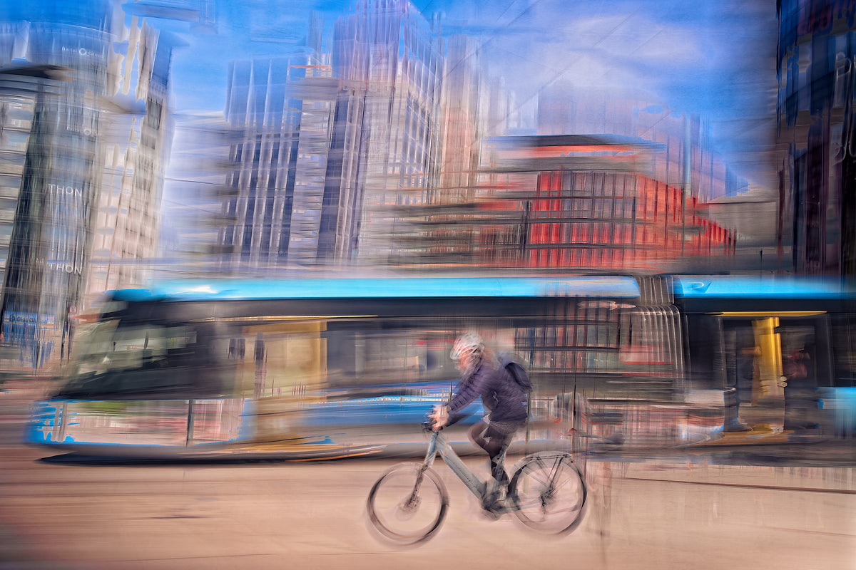 Downtown Deadline, a cyclist racing a tram through Oslo city streets — ICM photography cycling wall art print by Douglas Carr at Oslo Art Prints