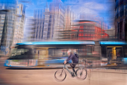 Downtown Deadline, a cyclist racing a tram through Oslo city streets — ICM photography cycling wall art print by Douglas Carr at Oslo Art Prints
